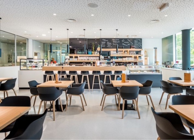Blick in das NOVA-das Café. Zu sehen ist der Thekenbereich und Tische mit Stühlen.