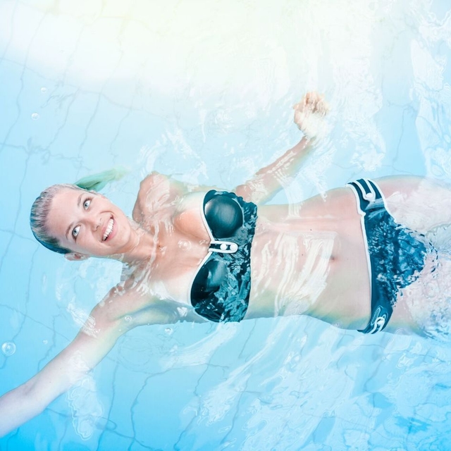 Dame in Bikini beim Rückenschwimmen.