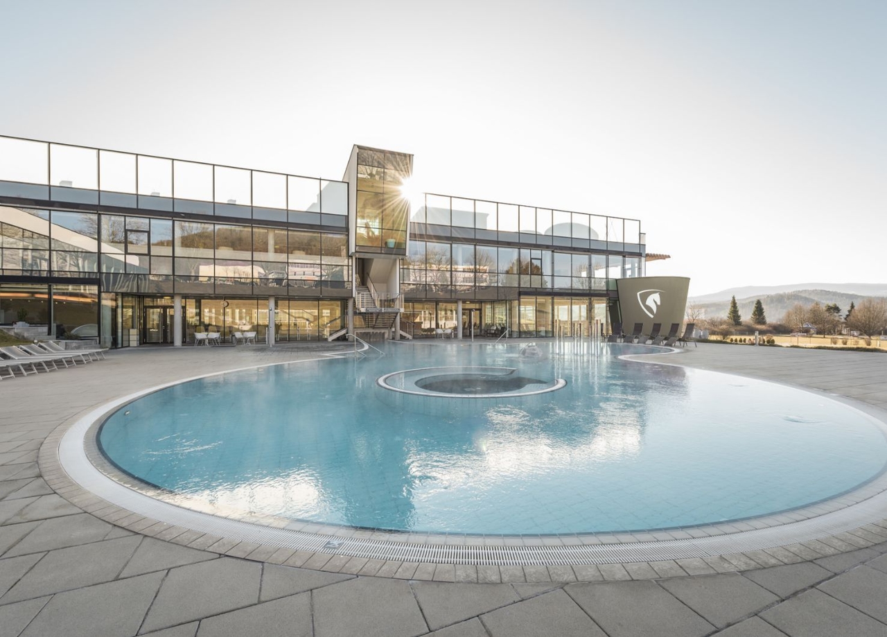 Blick auf das Außenbecken der Therme NOVA und das Gebäude.