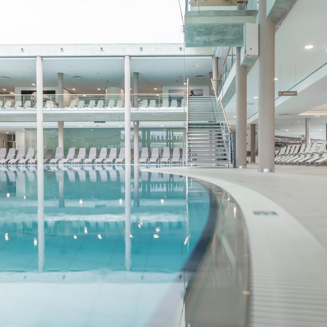 Blick auf den Innenbereich der Therme NOVA. Zu sehen ist ein Teil des Beckens und Liegen.