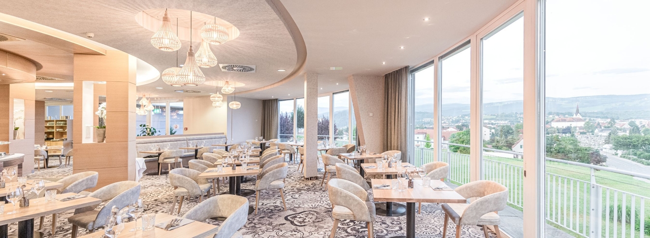 Blick in das NOVA Hotel-Restaurant. Zu sehen sind gedeckte Tische.