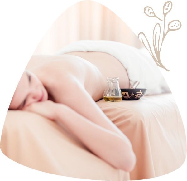 Dame liegt kurz vor Beginn der Massage am Bauch. Neben ihr das Massageöl.