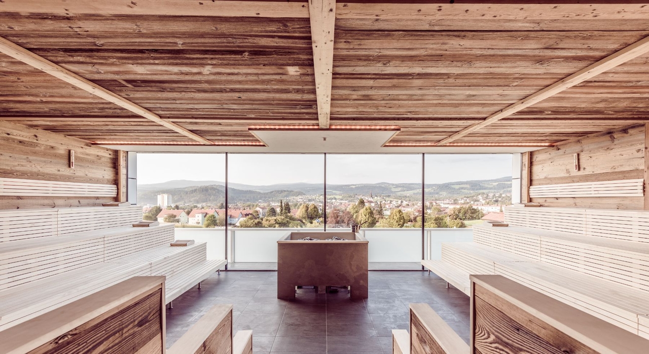 Blick in die Stubalmsauna. zu sehen ist der Heizkessel uns eine riesige Fensterfront mit Blick ins Grüne.