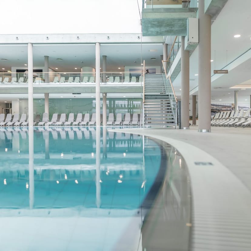 Blick auf den Innenbereich der Therme NOVA. Zu sehen ist ein Teil des Beckens und Liegen.