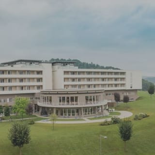 Blick auf das Hotel NOVA. Rund herum die grüne Wiesen.