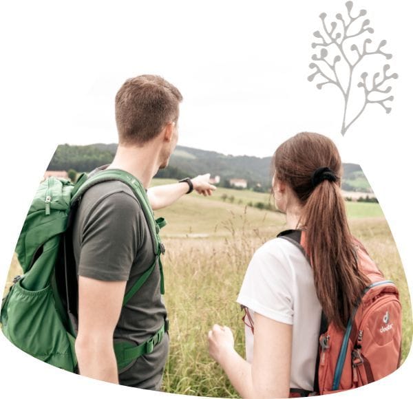Pärchen mit dem Rücken zur Kamera blickt auf die Weiden von Piber.