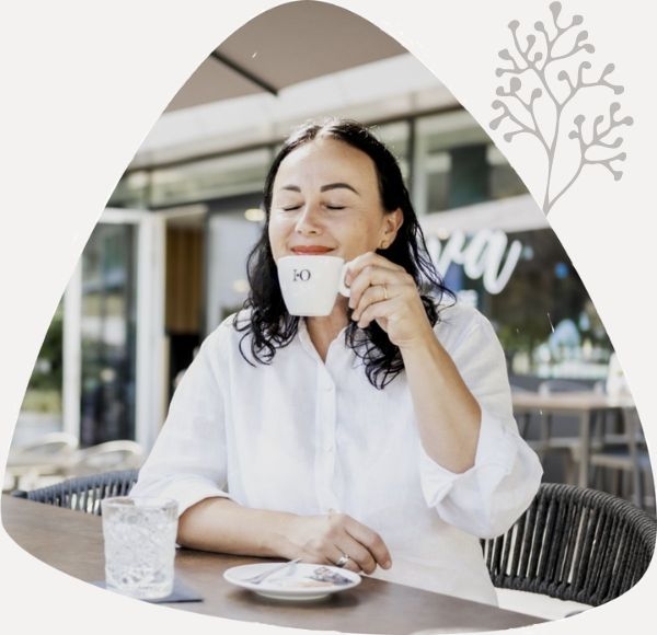 Dame sitzt auf der Terrasse vom NOVA-das Café und genießt eine Tasse Kaffee