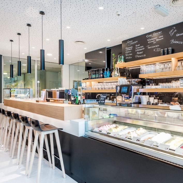 Blick auf die Eisvitrine und die Theke inkl. Hochstühle im NOVA-das Café