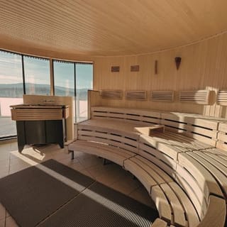 Blick in die Gmoaalmsauna. Zu sehen ist eine dreireihige Saunabank und der Heizkessel.