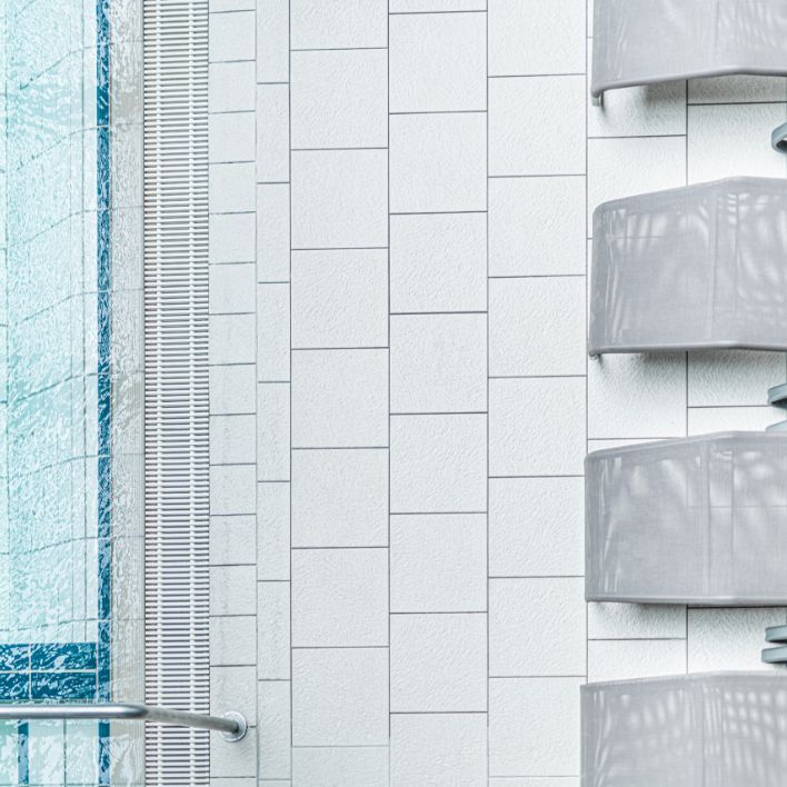 Vogelperspektive: Blick auf einen kleinen Teil des Beckens der Therme NOVA. Davor stehen die Liegen.