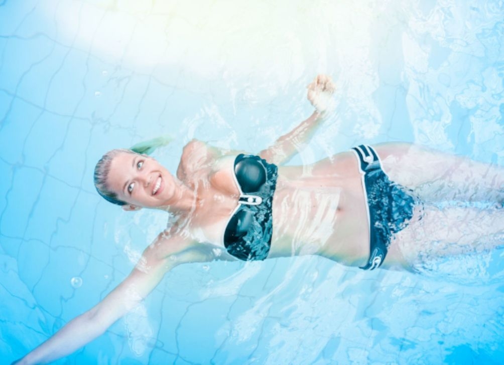 Frau schwimmt am Rücken im Thermalwasser